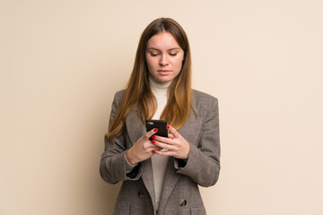 Fototapeta premium Young business woman sending a message with the mobile