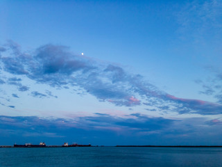 Obraz premium Cloudy sky at sunset over the water area of ​​the port.