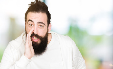Fototapeta premium Young hipster man with long hair and beard wearing sporty sweatshirt hand on mouth telling secret rumor, whispering malicious talk conversation
