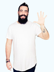 Young hipster man with long hair and beard wearing casual white t-shirt showing and pointing up with fingers number five while smiling confident and happy.