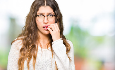 Young beautiful woman wearing glasses looking stressed and nervous with hands on mouth biting nails. Anxiety problem.