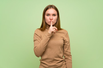 Young woman with turtleneck sweater showing a sign of silence gesture putting finger in mouth