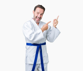 Handsome middle age senior man wearing kimono uniform over isolated background smiling and looking at the camera pointing with two hands and fingers to the side.