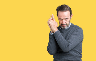 Handsome middle age senior man wearing a sweater over isolated background Holding symbolic gun with hand gesture, playing killing shooting weapons, angry face