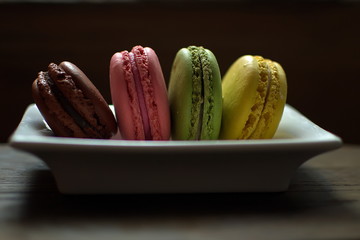Multi-colored macaroons on a wooden tray. Pink, yellow and green macaroon. - 278224338