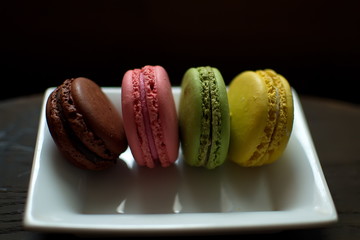 Multi-colored macaroons on a wooden tray. Pink, yellow and green macaroon. - 278224580