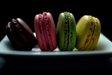 Multi-colored macaroons on a wooden tray. Pink, yellow and green macaroon. - 278224598