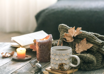 Cozy autumn morning breakfast in bed still life scene. Steaming cup of hot coffee, tea standing near window. Fall.