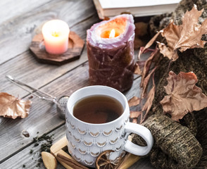 Cozy autumn morning breakfast in bed still life scene. Steaming cup of hot coffee, tea standing near window. Fall.