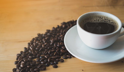 cup of coffee and beans on wooden table