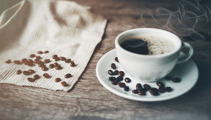 cup of coffee and beans on wooden table