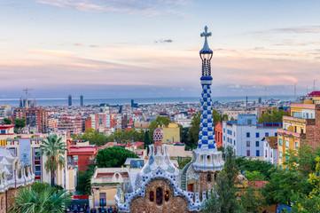 View of Barcelona from Park Guell at the sunset. In the foreground one of the colourful buildings...
