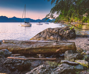 Sailing and rocky sunset beaches in the pacific north west with a lighthouse guiding the way through the Salish sea to Vancouver British Columbia Canada. © Jason