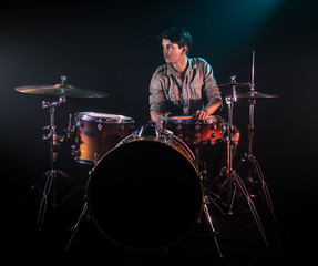 Fototapeta na wymiar musician playing drums, black background and beautiful soft light