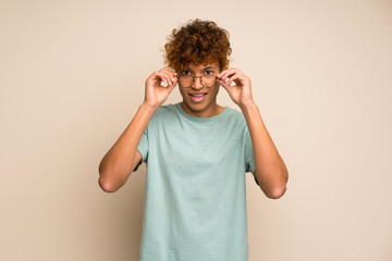 African american man with green shirt with glasses and surprised