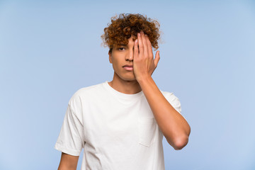 Young african american man with white shirt covering a eye by hand