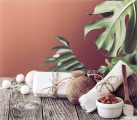 Fototapeta na wymiar Spa and wellness setting with flowers and towels. Bright composition on brown background with tropical flowers. Dayspa nature products with coconut