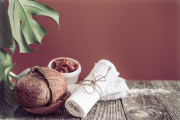 Spa and wellness setting with flowers and towels. Bright composition on brown background with tropical flowers. Place for text. Coconut