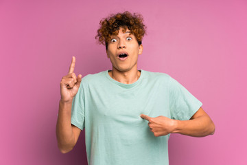 Young african american man over isolated purple wall with surprise facial expression