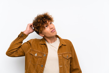 Young african american man over isolated white wall having doubts and with confuse face expression