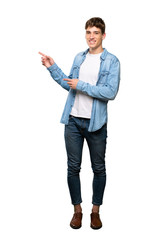 A full-length shot of a Handsome young man pointing finger to the side over isolated white background