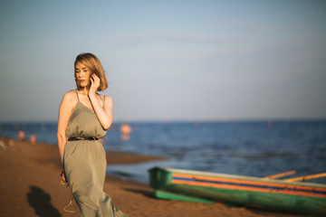 Young slim girl sitting on board rescue boat on shore