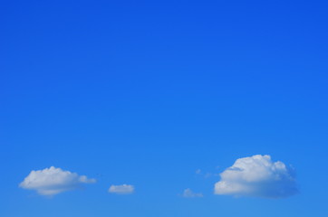 small fluffy clouds in the blue sky.