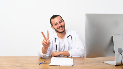 Doctor Colombian man smiling and showing victory sign