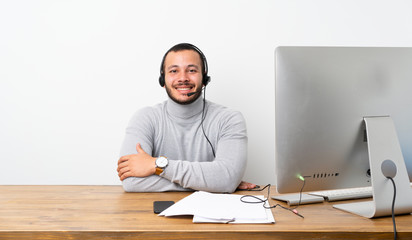 Telemarketer Colombian man keeping the arms crossed in frontal position