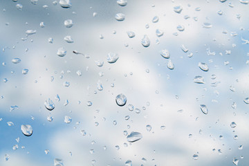 water drops (rain) on glass against a cloudy sky