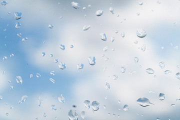 water drops (rain) on glass against a cloudy sky