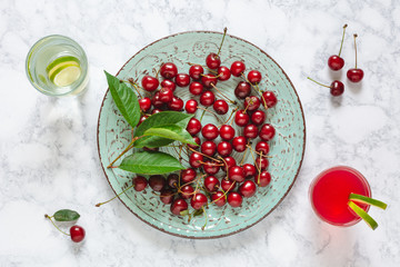 Fresh cherries with leaves on a plate