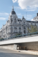 Madrid, Spain - June 20, 2019: The shelter under a bridge of a homeless person, contrasts with a luxurious building in the center of Madrid.