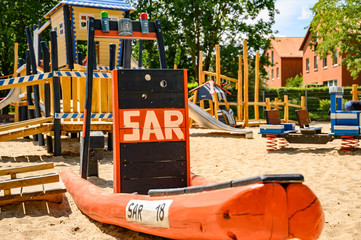 Various wooden playground equipment on a public playground in Berlin with the theme police and rescue.