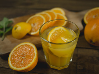 Sok pomarańczowy w otoczeniu pokrojonej pomarańczy