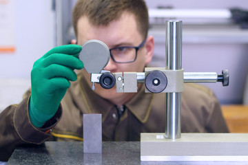 man makes measurements of the part, the specialist conducts metrological measurements