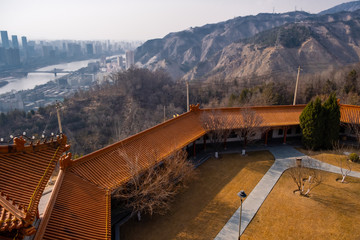 View on the temple garden and pavilion roof with mountain landscape and city view on background