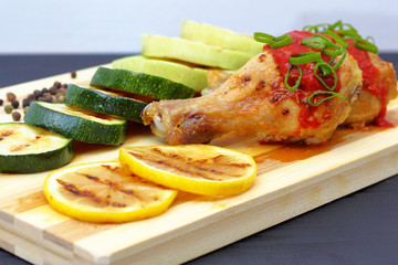 grilled chicken with vegetables on a wooden board