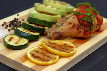 grilled chicken with vegetables on a wooden board