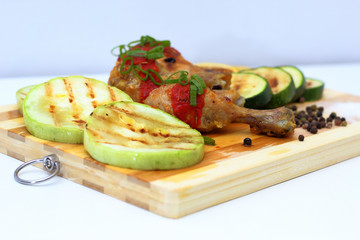 grilled chicken with vegetables on a wooden board