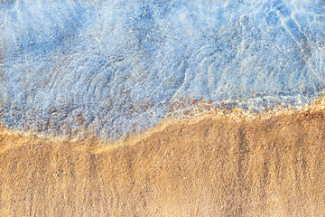Aqua background with blue water and yellow sand top view