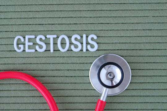 Gestosis text from white letters on  green background with  stethoscope, medical concept diagnostics, treatment, healthcare.