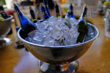 Bottle of champagne in bucket of ice. Bar counter.