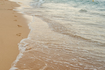 Footprints of human feet on the sand near the water on the beach