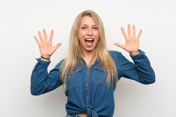 Young blonde woman over isolated white wall counting ten with fingers