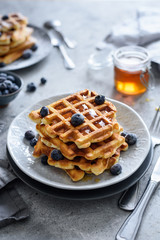 Viennese waffles with honey and blueberries on the background, selective focus 