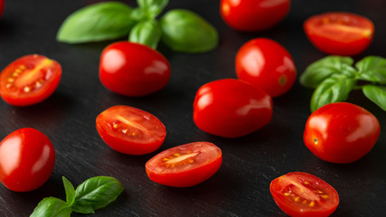 Red Baby Plum Tomatoes on black rustic background