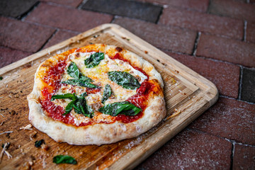 Homemade Margherita pizza on a wood cutting board