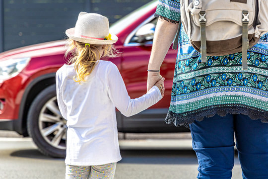 Mutter und Kind im Stra&szlig;en Verkehr beim &Uuml;berqueren der Fahrbahn auf dem Schulweg