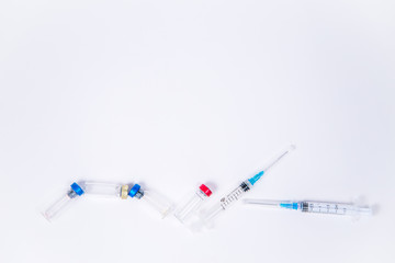 Veterinary and medical glass vials and two syringes for vaccination on a white isolated background. Liquid drug or vaccine to treat people and Pets against viruses, diseases, flu, rabies. Copy spase